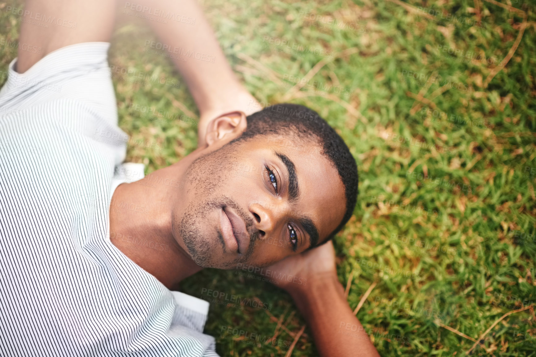 Buy stock photo Portrait, peace and black man on grass in garden of summer  for wellness or mindfulness. Face, relax and sunshine with confident young person lying in green field from above for break or rest
