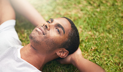 Buy stock photo Face, thinking and black man on grass in garden of summer home for peace, wellness or mindfulness. Nature, field and relax with thoughtful young person lying on ground from above for break or rest