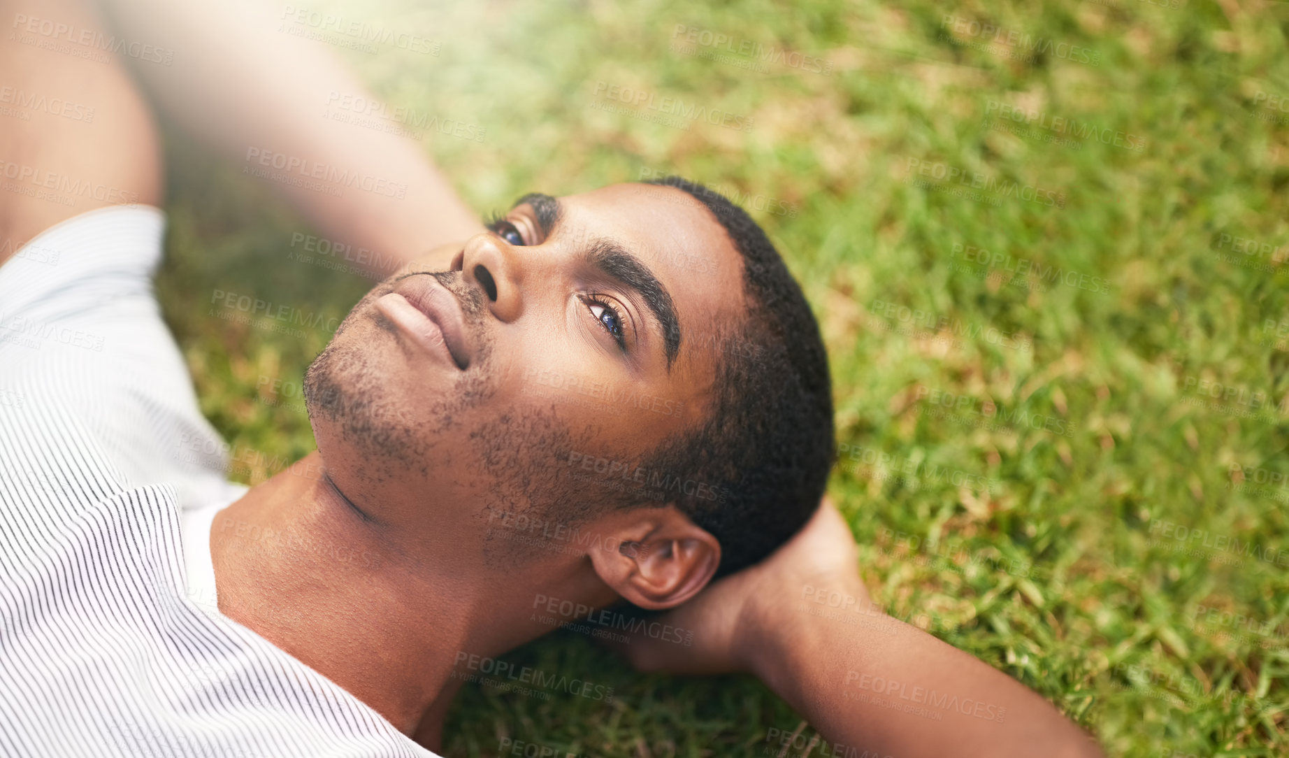 Buy stock photo Face, thinking and black man on grass in garden of summer home for peace, wellness or mindfulness. Nature, field and relax with thoughtful young person lying on ground from above for break or rest