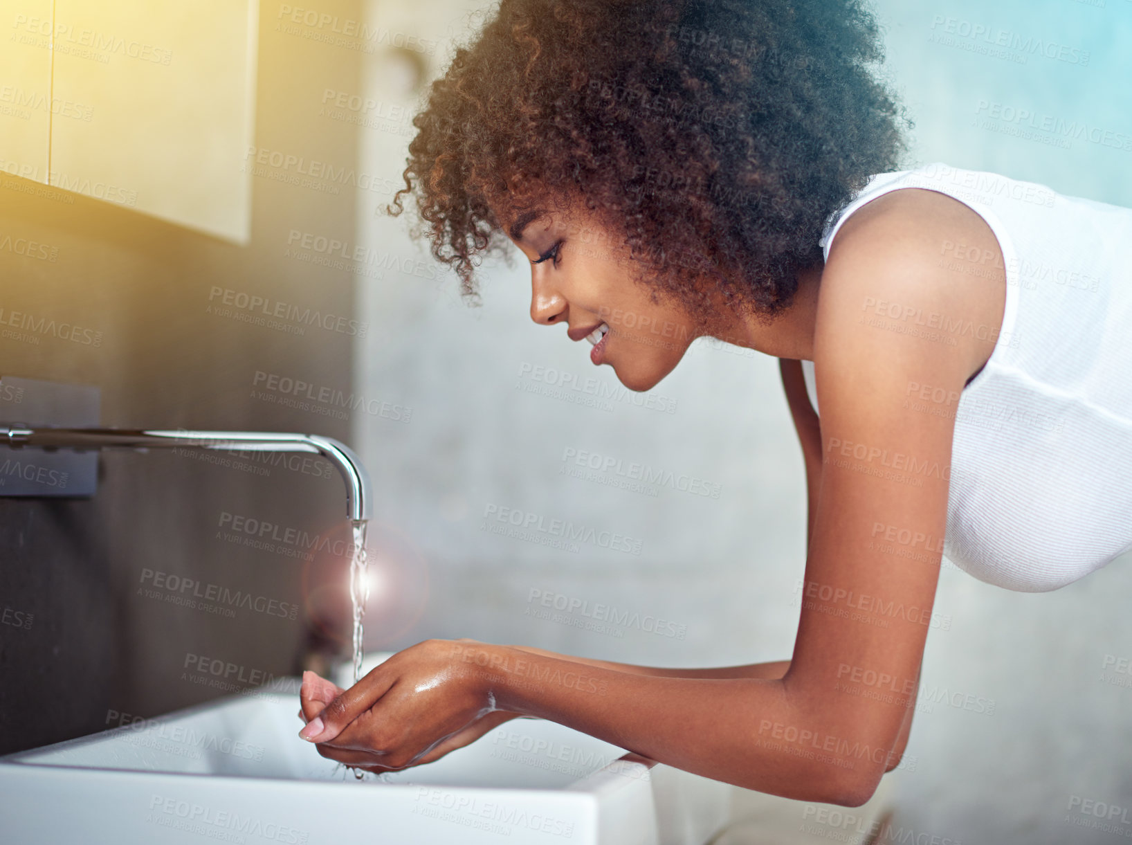 Buy stock photo Cropped shot of a young woman washing her face in the bathroom