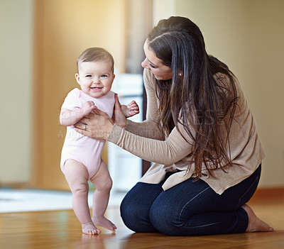 Buy stock photo Shot of a mother helping her baby girl stand