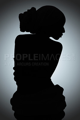 Buy stock photo Silhouette shot of a young woman posing against a gray background