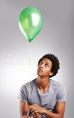 Buy stock photo Thinking, balloon and black man with birthday, sad and African person on grey studio background. Guy, mockup space and model with decoration and decision with choice and depression with mental health