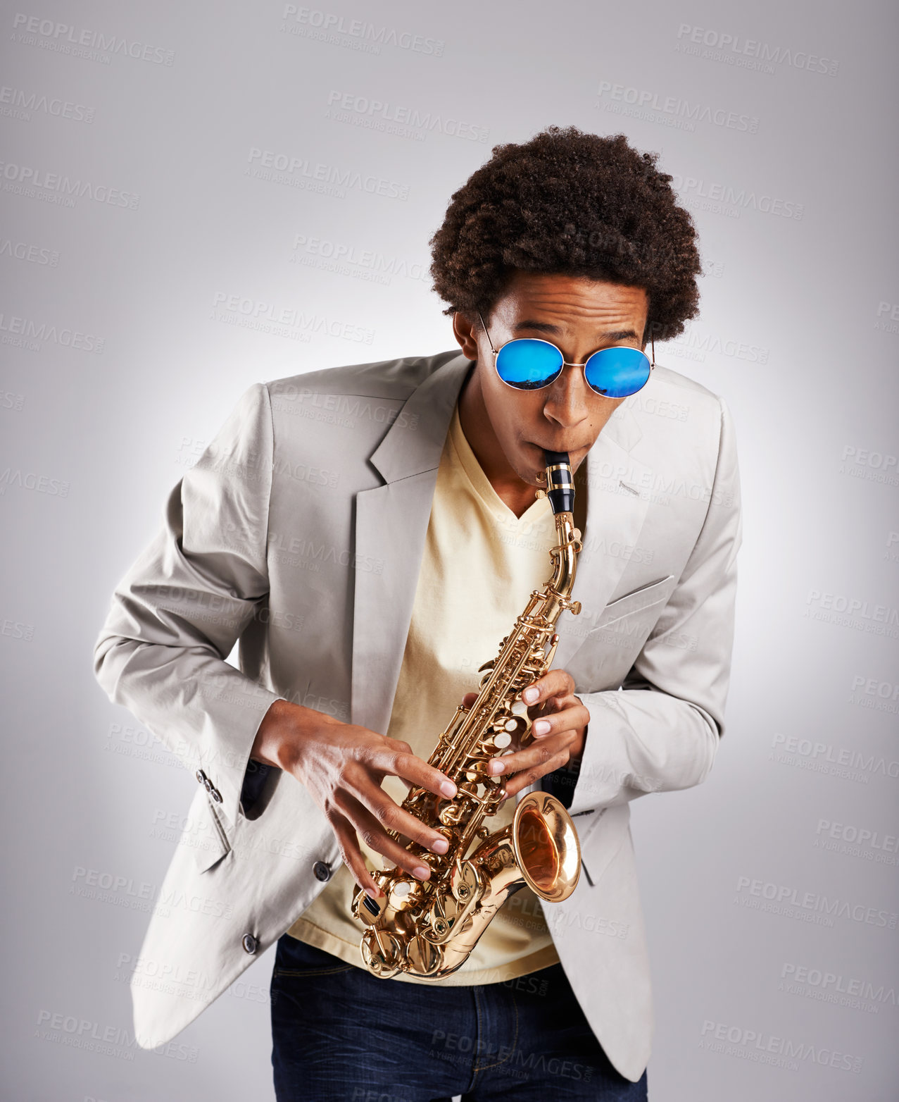 Buy stock photo Happy, black man and music, playing the saxophone with casual suit and sunglasses in studio. African musician, jazz and instrument with confidence and trendy outfit for band with gray background