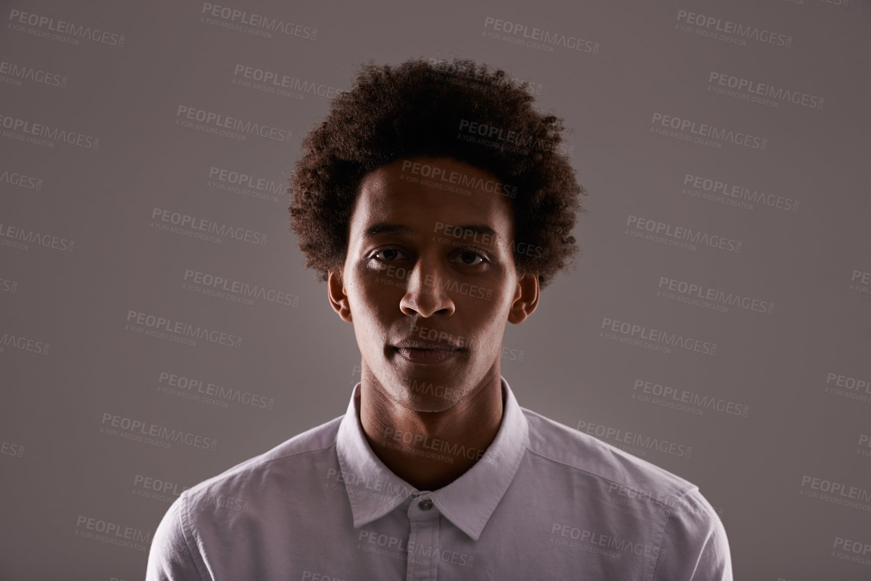 Buy stock photo Studio shot of a young man posing against a gray background