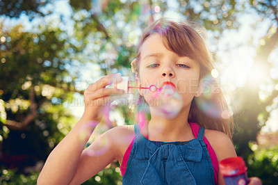 Buy stock photo Child, blowing and bubbles in garden or playing in summer sunshine in backyard for holiday, carefree or happy. Kid, girl and youth in California in outdoor nature or fun for vacation, weekend or park
