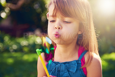 Buy stock photo Young girl, backyard and blowing pinwheel, garden and enjoying freedom of outside and fun. Pretty little child, outdoor and summer for playing, toy and windmill for holidays and nature sunshine