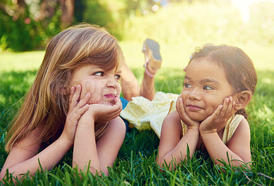 Buy stock photo Shot of two adorable little girls lying next to each other on the grass