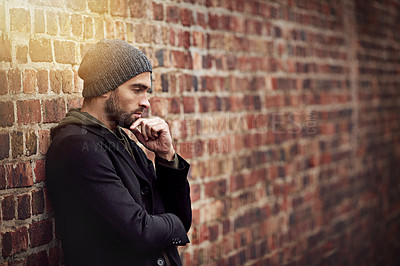 Buy stock photo Fashion, man and thinking in brick wall outdoor with trendy, cool and style for urban with idea. Male person, choice and planning for weekend or holiday with winter outfit and stylish in Germany