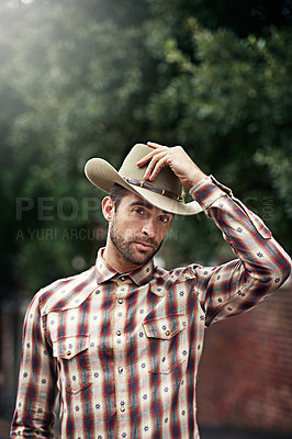 Buy stock photo Man, portrait and outdoor cowboy style, western culture and countryside ranch in Texas. Male person, hat and flannel fashion for farmer aesthetic, nature and plaid trend by trees or outside bush