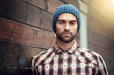 Buy stock photo Portrait, confident and man on wood wall background outdoor in casual clothes, outfit or apparel. Face, serious and stylish person in beanie, shirt and trendy fashion for profile picture in Spain