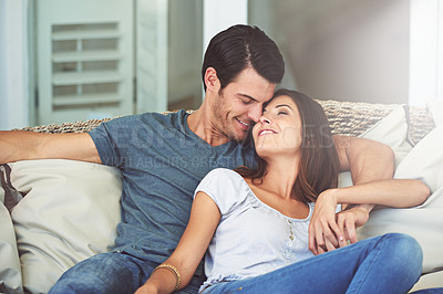 Buy stock photo Love, smile and couple relaxing on sofa by patio cuddling and bonding for marriage at home. Happy, romance and young man and woman resting together on couch by outdoor porch of modern house.