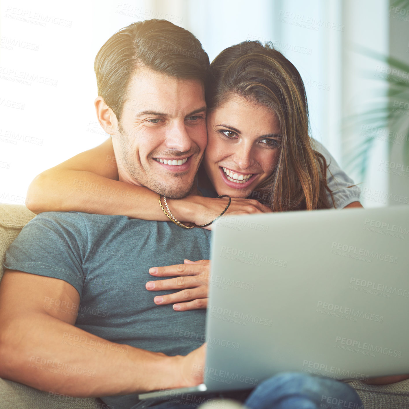 Buy stock photo Laptop, happy and woman embracing man on sofa networking on social media, website or internet. Smile, love and female person hugging husband reading online blog with computer in living room at home.