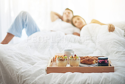 Buy stock photo Shot of a loving young couple enjoying breakfast in bed