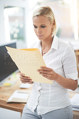 Buy stock photo A businesswoman reading a document in her office