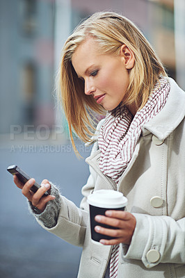 Buy stock photo Woman, smartphone and coffee in city, winter or texting with scarf, fashion and reading on road. Girl, person and phone on mobile app for notification on urban sidewalk with social media in Cape Town