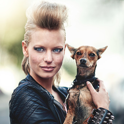 Buy stock photo Cropped portrait of an edgy young woman holding her small dog outdoors