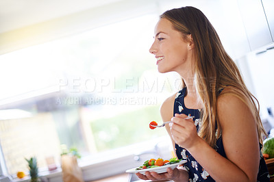 Buy stock photo Shot of a young woman eating a bowl of strawberries at home