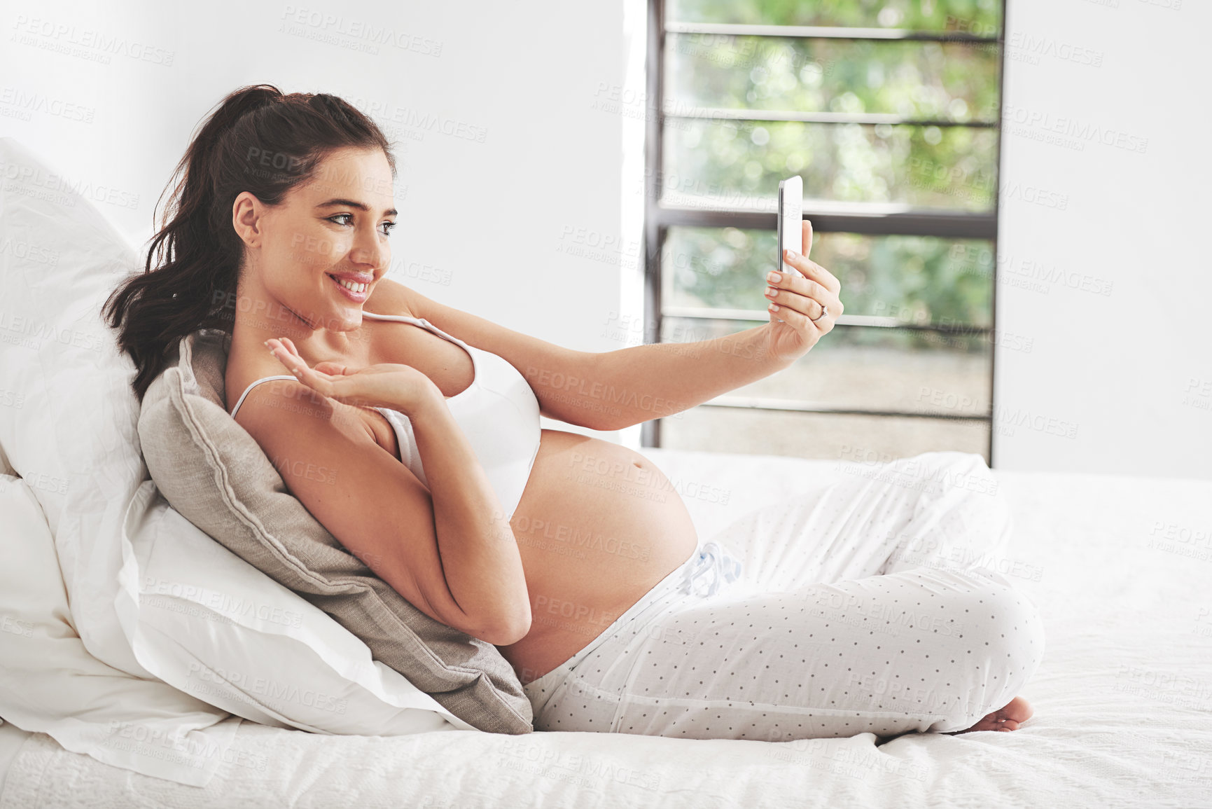 Buy stock photo Pregnant woman, phone selfie or video call in home bedroom for communication or online consultation. Wave, mom or happy mother with mobile app for gynecology telehealth, pregnancy update or maternity
