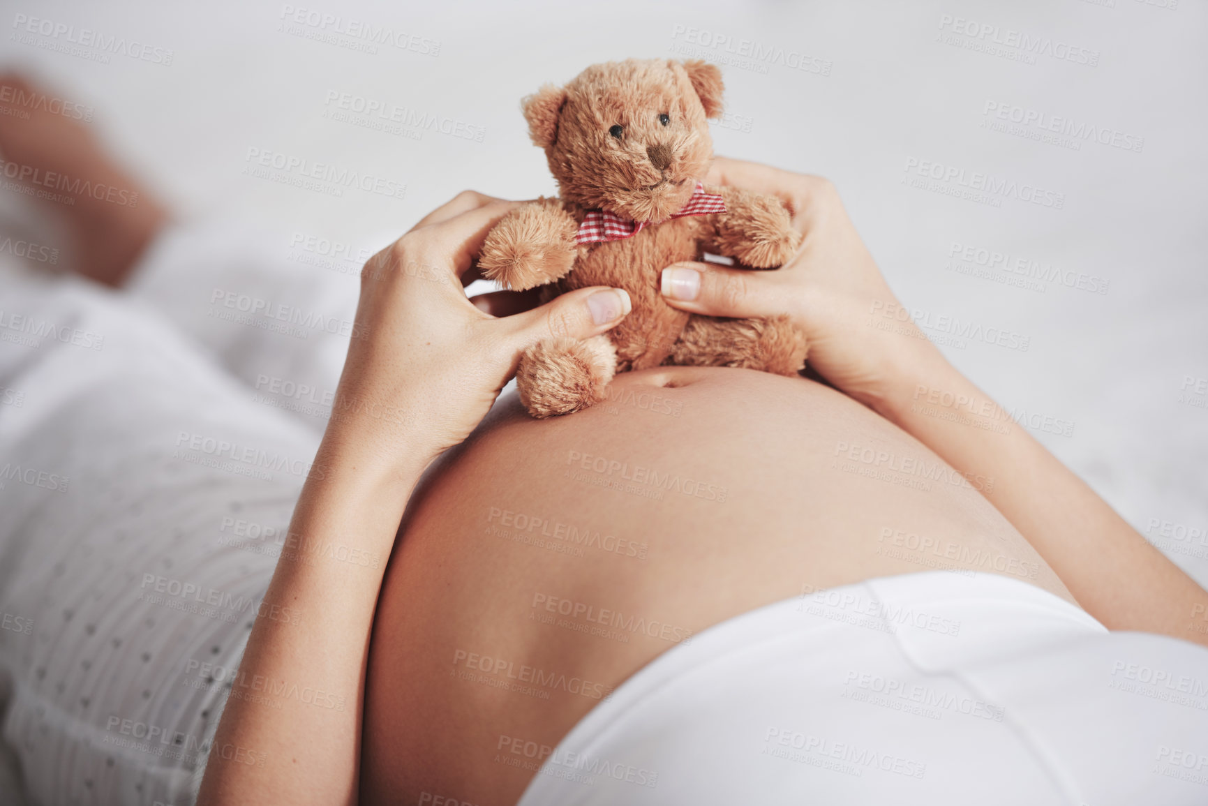 Buy stock photo Shot of a pregnant woman holding a teddy bear on top of her belly