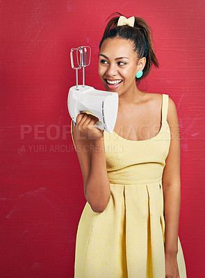Buy stock photo Happy woman, baker and fashion with electric mixer for ingredients or dessert on a red studio background. Young female person with smile for home appliance, baking or hospitality in yellow dress