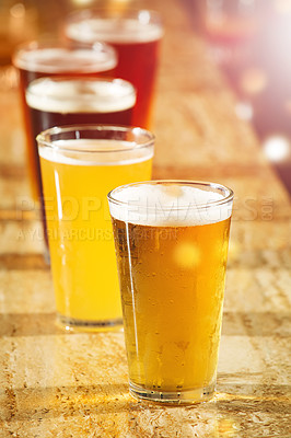 Buy stock photo Alcohol, beer and glasses at a bar table for party, club and happy hour promotion, sale and commercial background for event. Social lifestyle, drink and group of ale glasses at pub for cocktail sale