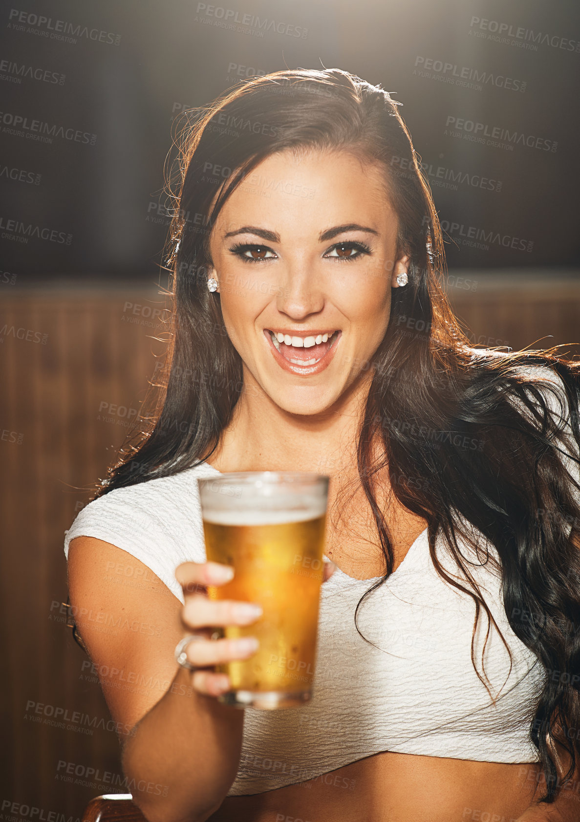Buy stock photo Shot of a young woman showing you a beer in a nightclub