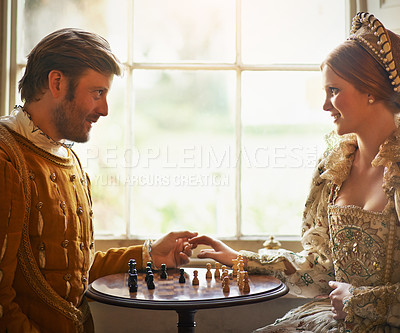 Buy stock photo Renaissance, couple and chess at home with holding hands, vintage and medieval costume in a palace. Window, luxury and queen together with smile from strategy game and talking while playing with love