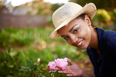 Buy stock photo Portrait of a young woman admiring the roses in her garden