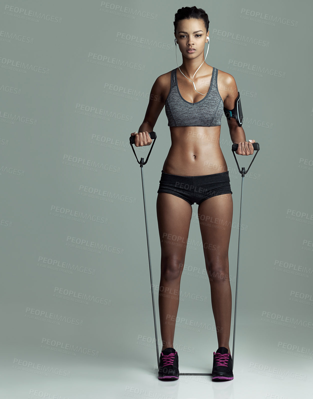 Buy stock photo Fitness, music and resistance band with portrait of woman in studio isolated on gray background. Exercise, equipment sports with serious athlete training at gym for challenge, health or performance