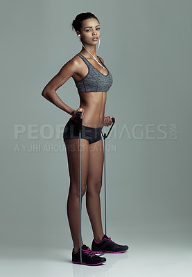 Buy stock photo Exercise, music and resistance band with portrait of woman in studio isolated on gray background. Fitness, equipment and workout with serious athlete training for challenge, health or performance
