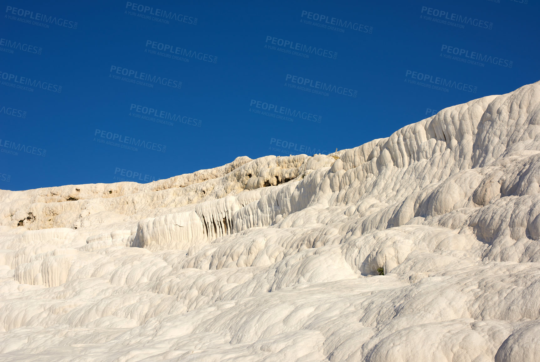 Buy stock photo Landscape of the Travertine pools and terraces in Pamukkale Turkey. Desert sand with textured pattern against a blue sky. Tourist holiday destination at rock cotton castle location during hot springs