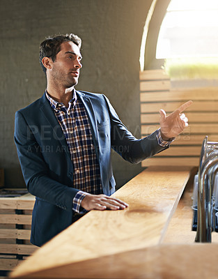 Buy stock photo Businessman, table and order drink in bar after long day at work, relax and pub counter for wine. Male person, buying and beer for leisure after job for happy hour, call and hand sign for waiter
