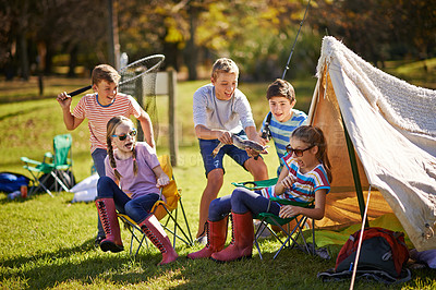 Buy stock photo Shot of a group of young friends hanging out at their campsite