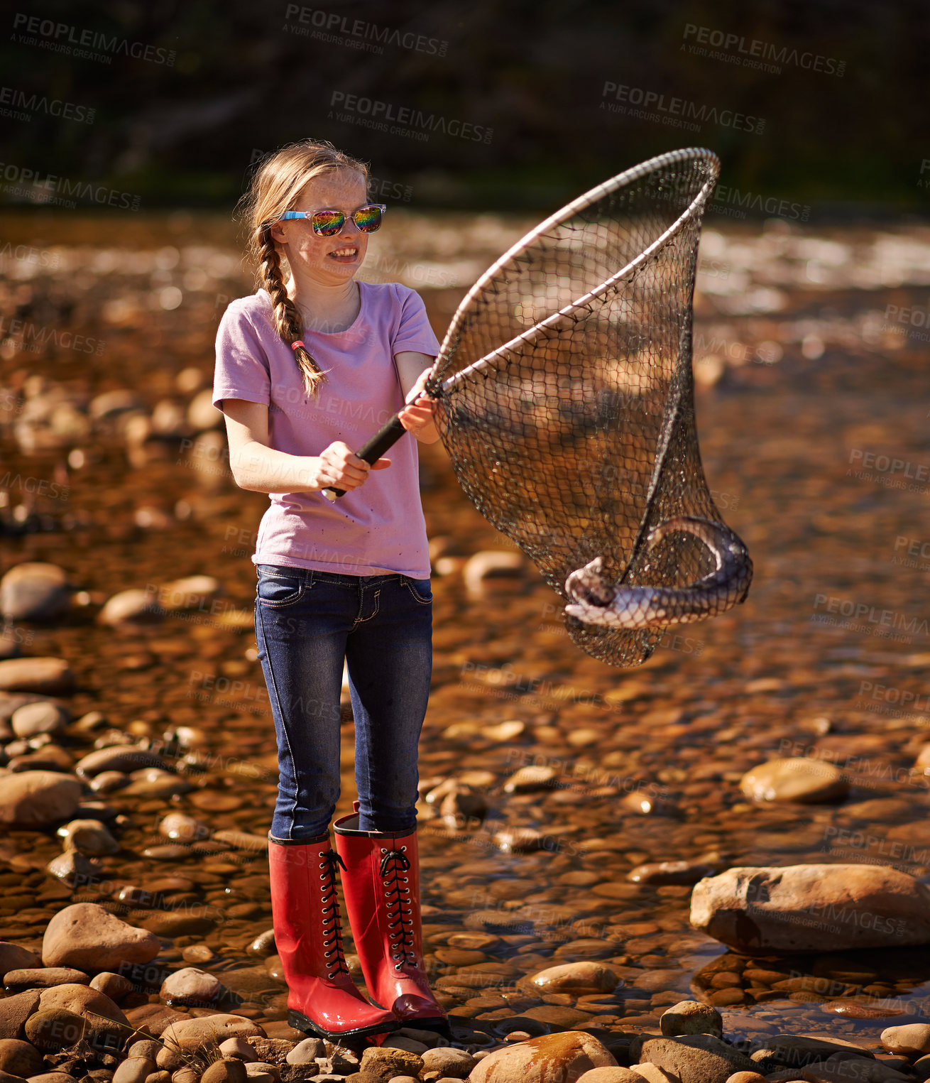 Buy stock photo Shot of a young girl holding a fishing net with a fish in it