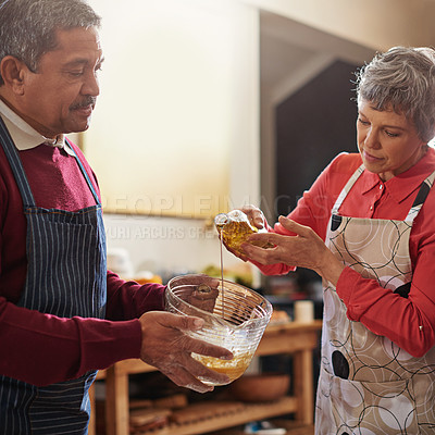 Buy stock photo Shot of a senior couple baking in the kitchen