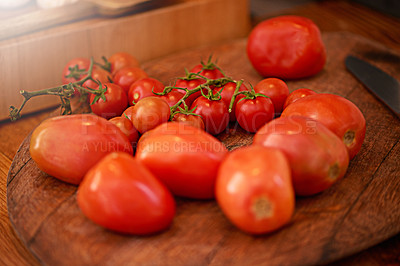 Buy stock photo Shot of a plum and cherry tomatoes on a table in a kitchen