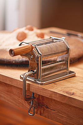 Buy stock photo Cooking, dough and pasta maker in kitchen on table, counter and wooden board for cuisine. Food, baking and culinary tool, machine or utensil for flour, ingredients and eggs for homemade noodles