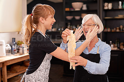Buy stock photo Shot of a senior woman and a younger woman having fun making past together