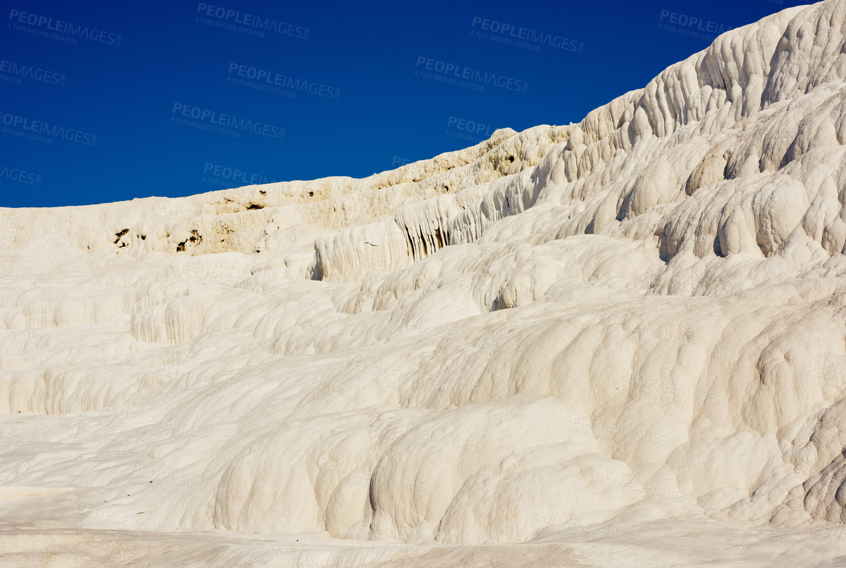 Buy stock photo Scenic view of travertine pools and terraces in Pamukkale, Turkey. Traveling abroad, overseas for vacation and tourism. Cotton castle area with a carbonated mineral after flowing thermal spring water