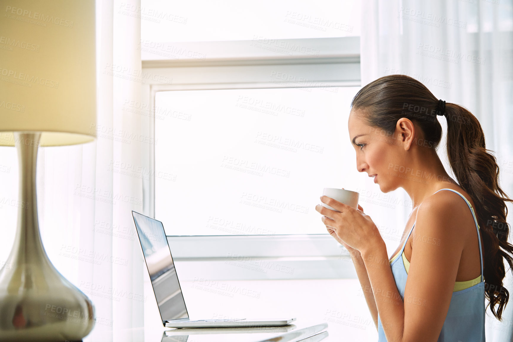 Buy stock photo Shot of a young woman using a laptop at home