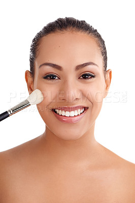 Buy stock photo Studio shot of a beautiful young woman applying blush to her cheeks