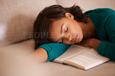 Buy stock photo Cropped shot of a young woman napping on the sofa with a book