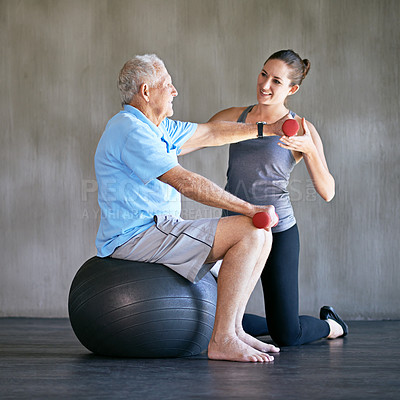 Buy stock photo Personal trainer, dumbbells and smile of senior man on ball for fitness or rehabilitation at gym on mockup. Elderly person, weightlifting and physiotherapist help for body health or physical therapy