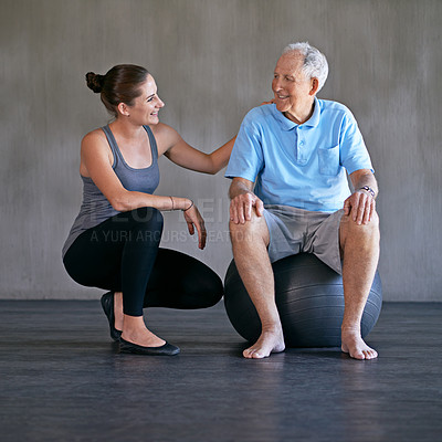 Buy stock photo Exercise ball, consultation and physiotherapist with man for muscle exercise consultation at clinic. Physical therapy, happy and healthcare worker helping senior patient at rehabilitation center.