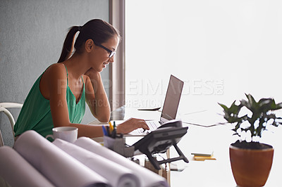 Buy stock photo Business woman, reading and typing on laptop for planning, research and real estate website in her home office. Architecture worker, realtor or freelancer with computer for floor plan or blueprint