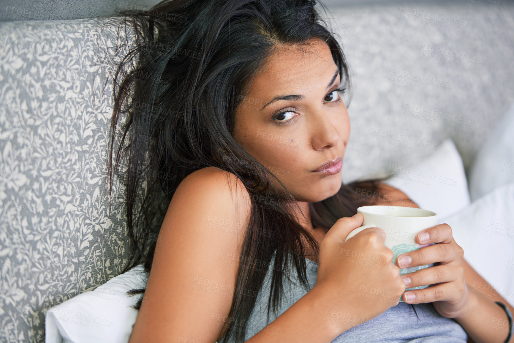 Buy stock photo Woman, portrait and tired or drinking coffee in bed for early morning in apartment or exhausted, caffeine or house. Female person, face and latte beverage on Monday for unhappy, moody or insomnia
