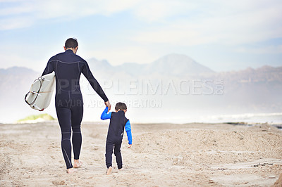 Buy stock photo Surfboard, man and child on beach, holding hands and mountain on outdoor bonding adventure. Nature, father and son at ocean for surfing, teaching and learning together with support, trust and growth.