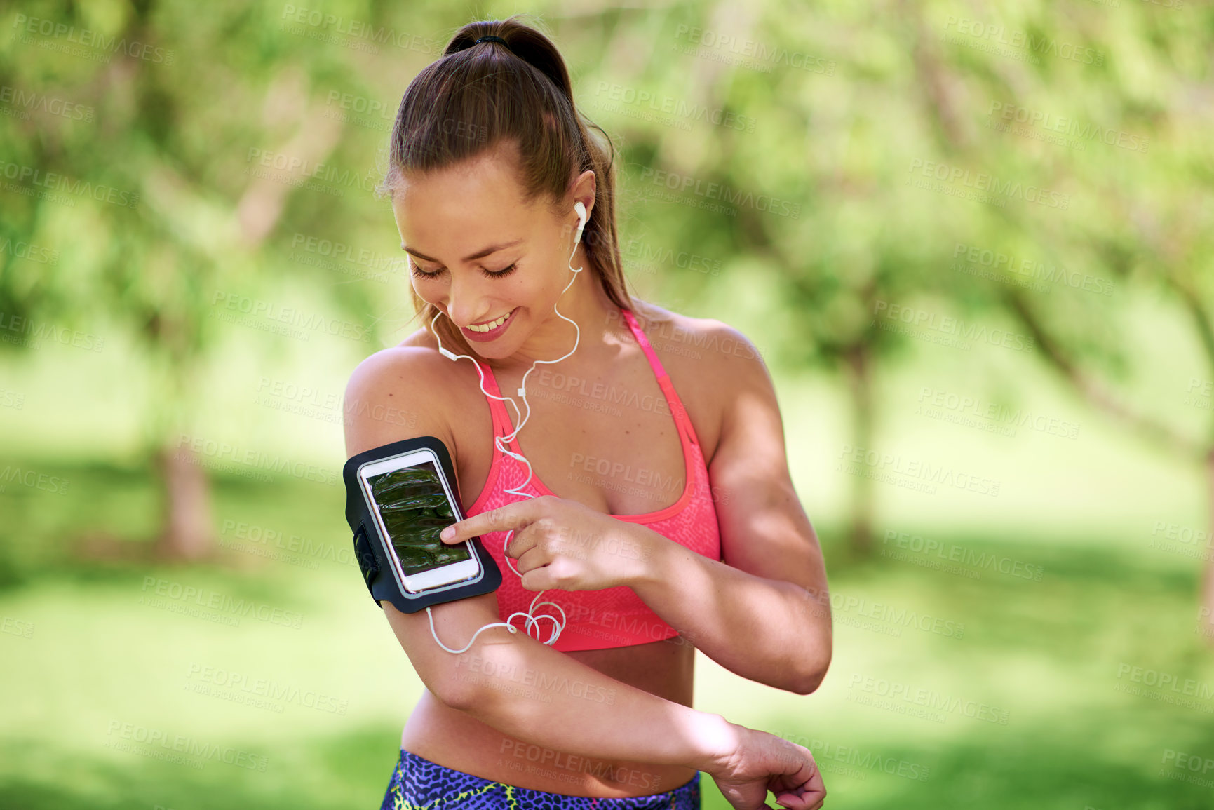 Buy stock photo Fitness, girl and smartphone on arm in outdoor for activity tracking, workout and check notifications or nutrition application. Woman, mobile and online with earphones for streaming audio and music.