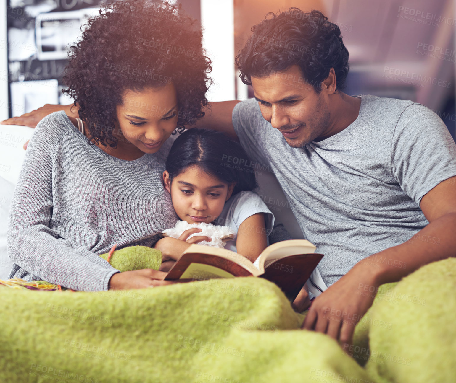 Buy stock photo Child, father and mother reading book in a family home for story time on a lounge sofa with a smile. A woman, man and girl child together for development, learning and love for a fantasy or fairytale